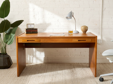 Load image into Gallery viewer, Image 1 of 22: Vintage Danish modern teak writing desk featuring a rectangular warm honey-brown wood top, two slim drawers with recessed horizontal handles, raised side edges, and straight panel-style legs.

