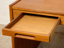 Load image into Gallery viewer, Image 19 of 22: Close-up of a mid-century modern wooden desk with a drawer pulled open, showcasing the warm medium-brown wood grain and a built-in pull handle.
