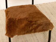 Load image into Gallery viewer, Image 12 of 15: A square stool or bench seat upholstered in rich brown faux fur or sheepskin, supported by a black metal frame, set on a textured beige rug.
