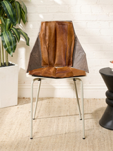 Load image into Gallery viewer, Image 1 of 16: Mid-century sculptural chair featuring folded caramel and dark brown cowhide upholstery, angular origami-inspired backrest and seat, contrasting dark side panels, and slender silver-tone metal legs.
