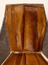 Load image into Gallery viewer, Image 8 of 16: A close-up of a brown leather chair back with vertical stitched panels and a dark gray fabric side panel, photographed against a light background.

