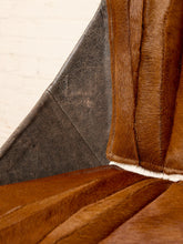 Load image into Gallery viewer, Image 10 of 16: Close-up detail of a brown fur or faux-fur upholstered chair or sofa corner, showing the texture of the outer material and a dark gray inner panel against a light off-white background.
