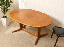 Load image into Gallery viewer, Image 1 of 28: Vintage Danish modern teak dining table featuring an oval golden-brown wood tabletop with visible natural grain, softly rounded edges, and a sculptural trestle base with angled feet. Includes two extension leaves.
