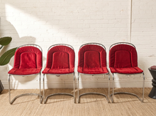 Load image into Gallery viewer, Image 1 of 15: Set of four vintage 1970s Italian dining chairs featuring curved chrome wire backrests, sculptural cantilever-style bases, and plush red upholstered cushions included with every chair.
