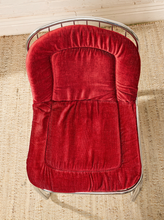 Load image into Gallery viewer, Image 9 of 15: A red velvet baby bassinet insert or cushion fitted on a silver metal wire bassinet, placed on a woven jute rug.
