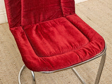 Load image into Gallery viewer, Image 11 of 15: A close-up of a red velvet upholstered chair cushion with a curved metal frame, set on a beige carpeted floor.
