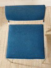 Load image into Gallery viewer, Image 4 of 14: Vintage dining chair featuring a navy blue upholstered seat, curved cylindrical padded backrest, open-back design, and slender chrome metal frame with angled legs.
