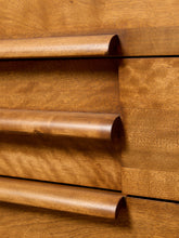 Load image into Gallery viewer, Image 9 of 16: Close-up of a wooden drawer front with three curved drawer pulls in a warm medium brown finish, set against matching wood grain panels.
