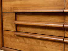 Load image into Gallery viewer, Image 10 of 16: Close-up of a wooden dresser or cabinet with three drawers, featuring curved horizontal handles and a warm medium-brown wood grain finish.
