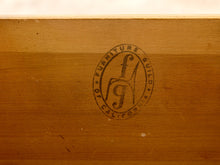 Load image into Gallery viewer, Image 15 of 16: Close-up of a wooden surface with a circular stamped logo reading 'Furniture Guild California' and a stylized fg mark.
