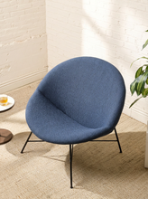 Load image into Gallery viewer, Image 2 of 17: Blue upholstered lounge chair by Claude Vassal featuring a wide rounded backrest, softly curved bowl-shaped seat, and slender black metal legs with angled supports.
