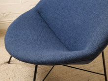 Load image into Gallery viewer, Image 11 of 17: A close-up of a modern blue upholstered chair with a textured fabric seat and thin black metal legs, set against a light brick wall and woven rug.

