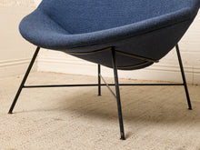 Load image into Gallery viewer, Image 15 of 17: A close-up of a blue upholstered chair with a black metal frame and legs, set on a beige textured rug against a light wall.
