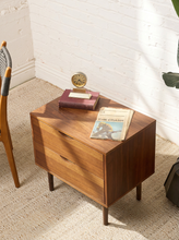 Load image into Gallery viewer, Image 3 of 16: Vintage mid-century modern wooden nightstand featuring two stacked drawers with recessed crescent-shaped pulls, warm walnut-tone wood grain, rectangular cabinet frame, and four slender tapered legs.
