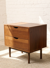 Load image into Gallery viewer, Image 5 of 16: Vintage mid-century modern wooden nightstand featuring two stacked drawers with recessed crescent-shaped pulls, warm walnut-tone wood grain, rectangular cabinet frame, and four slender tapered legs.
