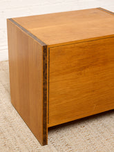 Load image into Gallery viewer, Image 9 of 17: Vintage mid-century modern rectangular wooden cabinet featuring a honey-brown wood grain finish, single flat-panel door, dark vertical metal pull, and contrasting darker wood trim along both sides.
