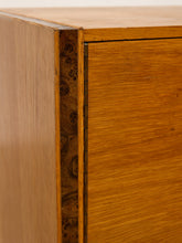 Load image into Gallery viewer, Image 13 of 17: Vintage mid-century modern rectangular wooden cabinet featuring a honey-brown wood grain finish, single flat-panel door, dark vertical metal pull, and contrasting darker wood trim along both sides.
