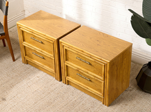 Load image into Gallery viewer, Image 3 of 21: Vintage honey oak nightstand featuring two drawers, natural wood grain, rounded faux-bamboo trim, and antique brass-tone horizontal handles, available as a pair.
