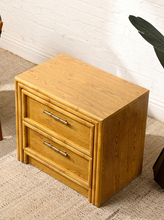 Load image into Gallery viewer, Image 9 of 21: Vintage honey oak nightstand featuring two drawers, natural wood grain, rounded faux-bamboo trim, and antique brass-tone horizontal handles, available as a pair.
