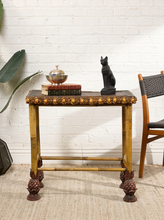 Load image into Gallery viewer, Image 1 of 20: Antique rectangular bamboo-style accent table featuring a dark brown embossed decorative tabletop, ornate gold-tone floral trim, slender golden bamboo legs, crossbar supports, and sculptural pineapple-like feet.
