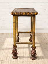 Load image into Gallery viewer, Image 8 of 20: Antique rectangular bamboo-style accent table featuring a dark brown embossed decorative tabletop, ornate gold-tone floral trim, slender golden bamboo legs, crossbar supports, and sculptural pineapple-like feet.
