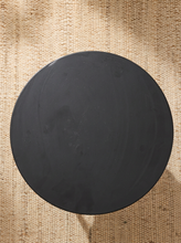 Load image into Gallery viewer, Image 7 of 14: Modern round black side table featuring a smooth circular tabletop, matte black finish, and sculptural tapered cone-shaped pedestal base with subtle surface marks.
