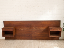 Load image into Gallery viewer, Image 3 of 22: Vintage Danish modern teak headboard featuring a long rectangular wood panel with rich reddish-brown grain and two adjustable open-box nightstands positioned near either end, compatible with queen or king beds.
