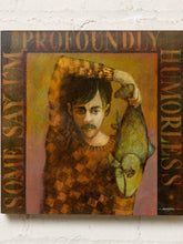 Load image into Gallery viewer, Image 2 of 9: A square art print or canvas featuring a stylized portrait of a man holding a fish, with the words 'PROFOUNDDLY' at the top and 'SOME SAY I'M HUMORLESS' along the sides, displayed against a white brick wall.

