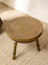 Load image into Gallery viewer, Image 3 of 13: Vintage round brass-tone foot warmer featuring a circular top with intricate floral and scrollwork engravings, a raised rounded rim, warm aged patina, and three short turned metal legs.
