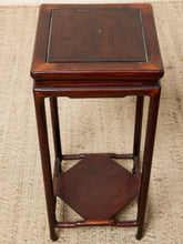 Load image into Gallery viewer, Image 8 of 16: A dark reddish-brown wooden side table with a square top, four legs, and a lower hexagonal shelf, photographed on a woven beige rug.
