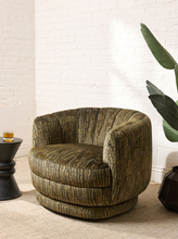Load image into Gallery viewer, Image 1 of 16: Rowan Swivel Chair in Kenai Olive featuring olive, mustard, and charcoal abstract linear patterned upholstery, a rounded barrel backrest, curved arms, a generously cushioned seat, and a low-profile circular swivel base.
