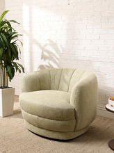 Load image into Gallery viewer, Image 1 of 16: Rowan Swivel Chair in Bay Leaf Olive featuring light olive textured upholstery, a rounded barrel backrest, softly curved arms, a generously cushioned seat, and a low-profile circular swivel base.
