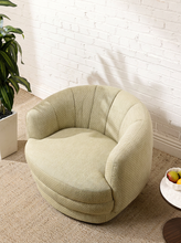 Load image into Gallery viewer, Image 2 of 16: Rowan Swivel Chair in Bay Leaf Olive featuring light olive textured upholstery, a rounded barrel backrest, softly curved arms, a generously cushioned seat, and a low-profile circular swivel base.
