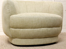 Load image into Gallery viewer, Image 13 of 16: A mid-century modern barrel chair upholstered in a light beige fabric with a small white geometric pattern, set against a white brick wall and textured floor.

