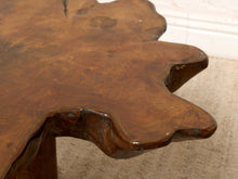 Load image into Gallery viewer, Image 9 of 16: Close-up of a rustic live-edge wooden table with a glossy brown finish, showing the natural grain and irregular contours of the tabletop.
