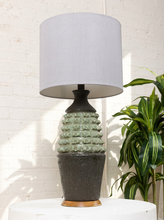 Load image into Gallery viewer, Image 5 of 17: Vintage table lamp with light gray drum shade and textured sage green and charcoal brown sculptural base
