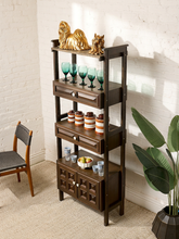 Load image into Gallery viewer, Image 3 of 25: Vintage dark wood étagère bookshelf featuring three open display shelves, two drawers with raised rectangular panel details, a lower double-door cabinet with geometric square panels, and round cream-colored knobs.
