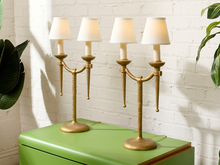 Load image into Gallery viewer, Image 3 of 21: Pair of vintage gold-tone metal table lamps, each featuring two gracefully curved arms, candle-style light fittings, smooth ivory tapered fabric shades, a slender central stem, and a rounded pedestal base.
