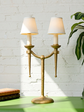 Load image into Gallery viewer, Image 9 of 21: Pair of vintage gold-tone metal table lamps, each featuring two gracefully curved arms, candle-style light fittings, smooth ivory tapered fabric shades, a slender central stem, and a rounded pedestal base.
