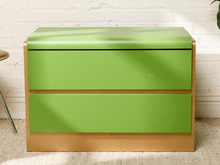 Load image into Gallery viewer, Image 4 of 16: A two-drawer nightstand with bright lime green fronts and a light natural wood frame, set against a white brick wall.
