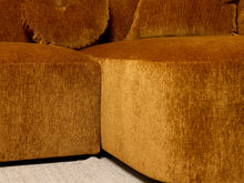 Load image into Gallery viewer, Image 15 of 16: Close-up of a mustard yellow textured fabric sectional sofa corner with matching cushions and a light woven rug visible at the base.
