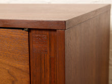 Load image into Gallery viewer, Image 16 of 24: Close-up of a mid-century modern wooden cabinet corner, showcasing a rich warm brown wood grain finish, dovetail joint construction, and a clean white textured wall background.
