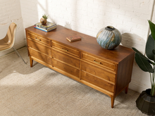 Load image into Gallery viewer, Image 3 of 21: Vintage mid-century modern nine-drawer walnut dresser by Dixie Furniture Co. featuring three upper drawers with brass-tone handles, six lower drawers with integrated pulls, warm brown wood grain, and slender tapered legs.
