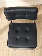 Load image into Gallery viewer, Image 6 of 17: 1970s-style counter stool featuring black button-tufted upholstered seat and backrest, polished chrome tubular cantilever frame, curved sled-style base, and integrated metal footrest.
