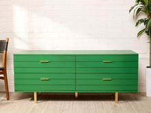 Load image into Gallery viewer, Image 1 of 15: Vintage four-drawer dresser featuring a vibrant Kelly green painted finish, long rectangular silhouette, four wide drawers with brass-tone rectangular pulls, smooth flat top, and low-profile base.
