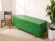 Load image into Gallery viewer, Image 3 of 15: Vintage four-drawer dresser featuring a vibrant Kelly green painted finish, long rectangular silhouette, four wide drawers with brass-tone rectangular pulls, smooth flat top, and low-profile base.
