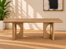 Load image into Gallery viewer, Sylvia dining table in Blonde Oak with rectangular rounded-edge top and sculptural fluted pedestal bases with circular cutouts.
