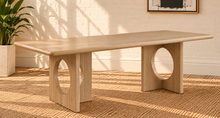 Load image into Gallery viewer, Sylvia dining table in Blonde Oak with rectangular rounded-edge top and sculptural fluted pedestal bases with circular cutouts.
