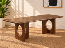 Load image into Gallery viewer, Sylvia dining table in Natural Brown Walnut with rectangular rounded-edge top and sculptural fluted pedestal bases with circular cutouts.
