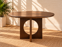 Load image into Gallery viewer, Sylvia round dining table in Natural Brown Walnut with sculptural fluted pedestal base and distinctive circular cutouts.

